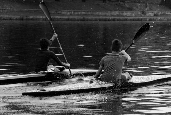 a couple of people riding on the back of a kayak