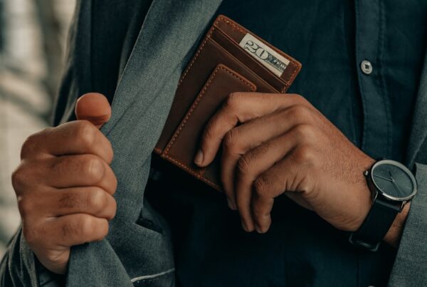 a man holding a wallet and a watch