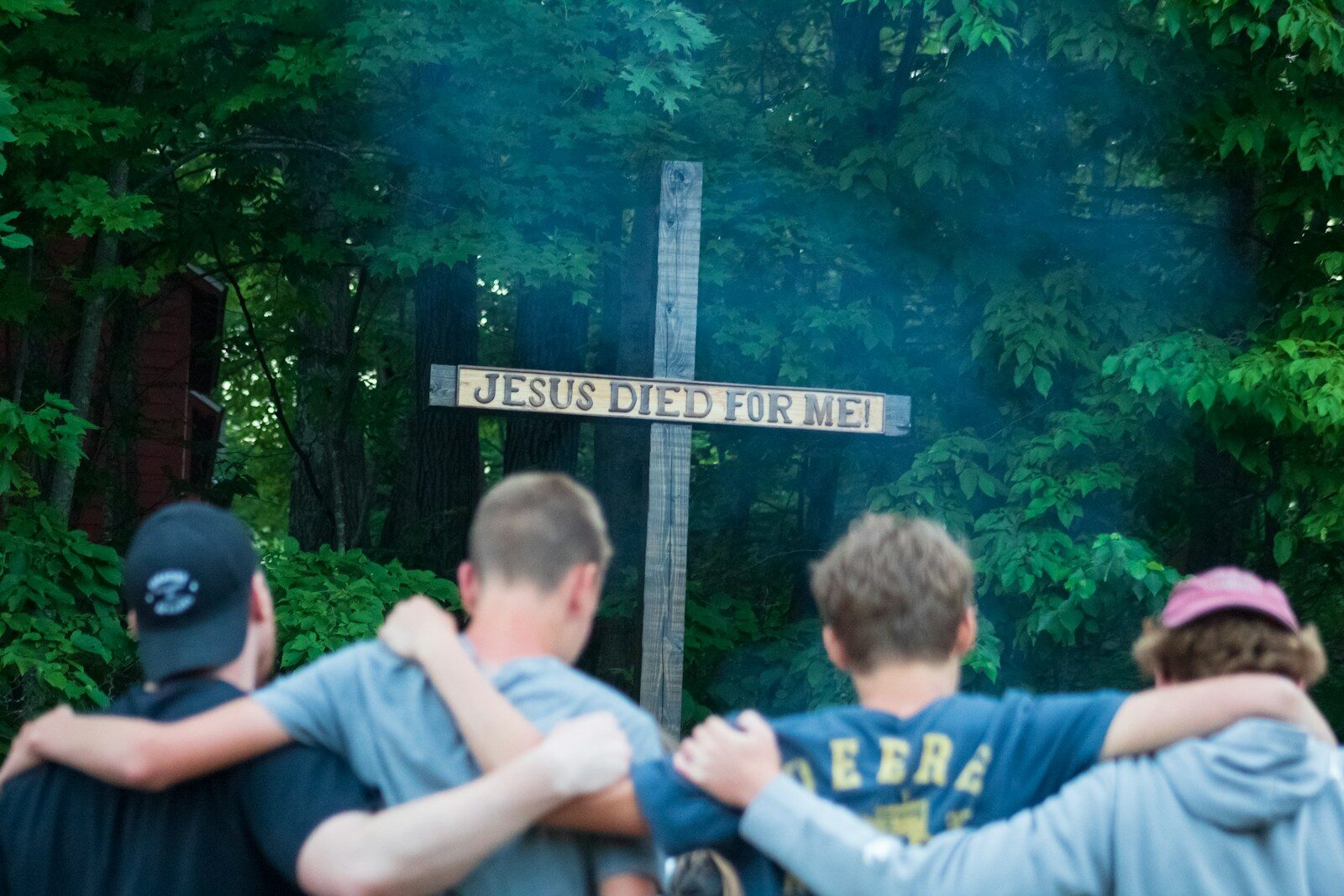 A group of people standing around a cross
